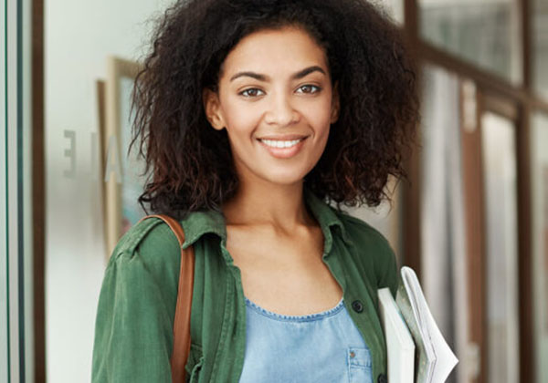 Young beautiful african girl student resting relaxing sitting in cafe smiling drinking coffee. Copy space.